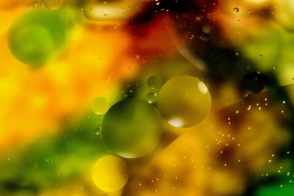 These celestial objects are oil drops in water.You can also see optic physics in this macro world showing light and shadows of particles among them.